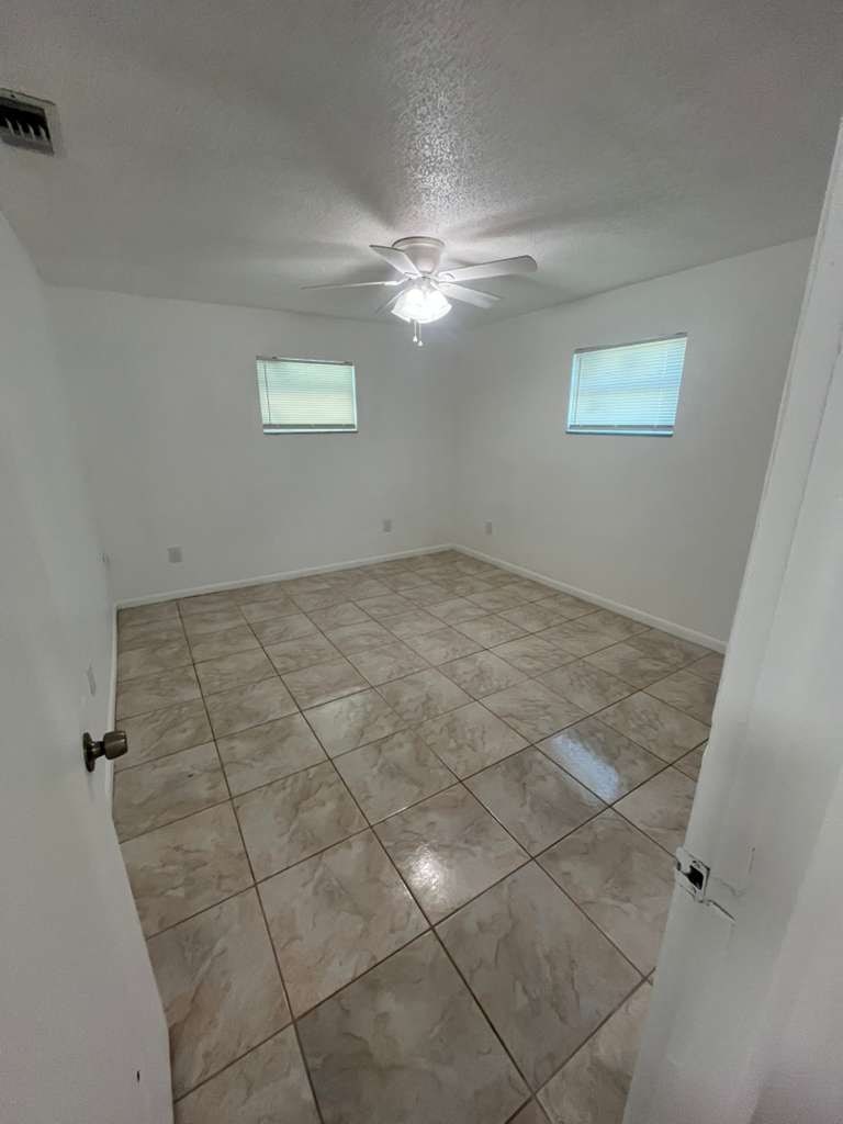 A room with tile flooring and a ceiling fan.