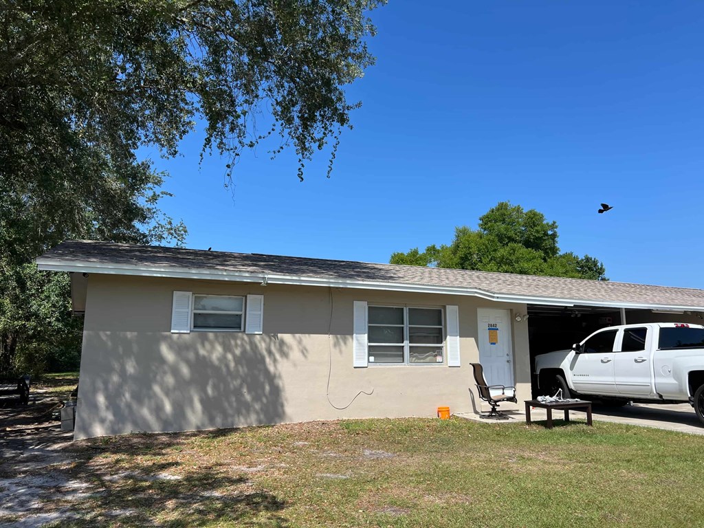 A house with a white car in the garage.