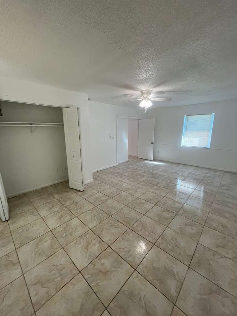 A room with tile flooring and a ceiling fan.