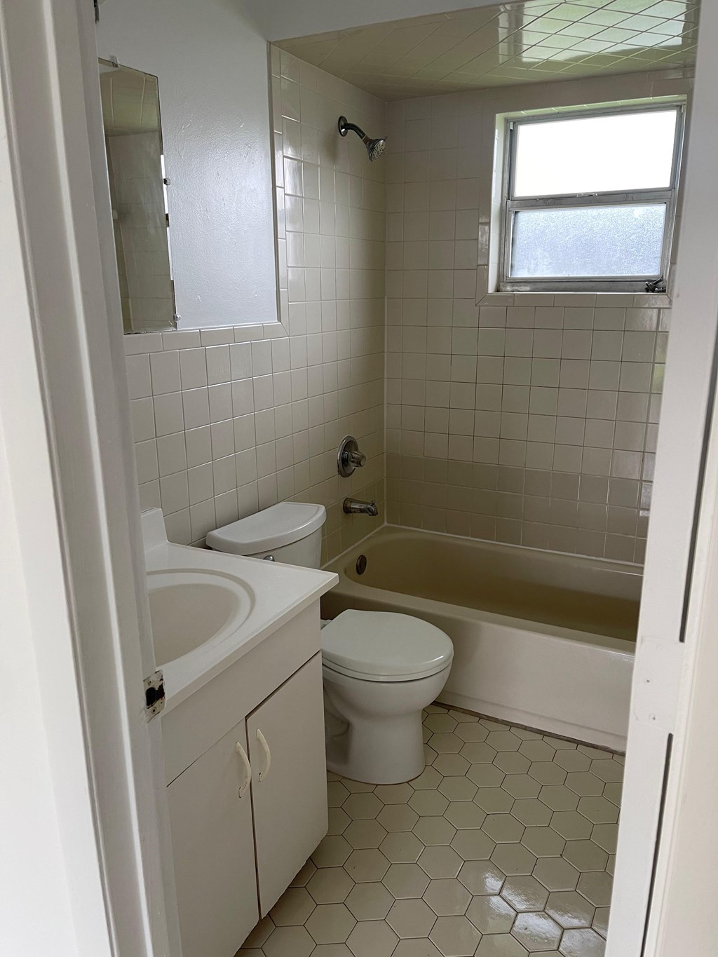 A white bathroom with a toilet, sink, and bathtub.