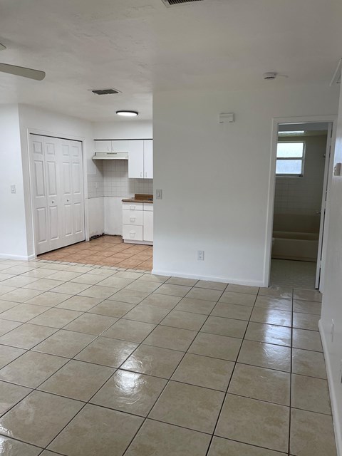 A kitchen with white cabinets and a tiled floor.