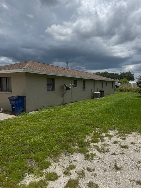 A house with a blue trash bin in front of it.
