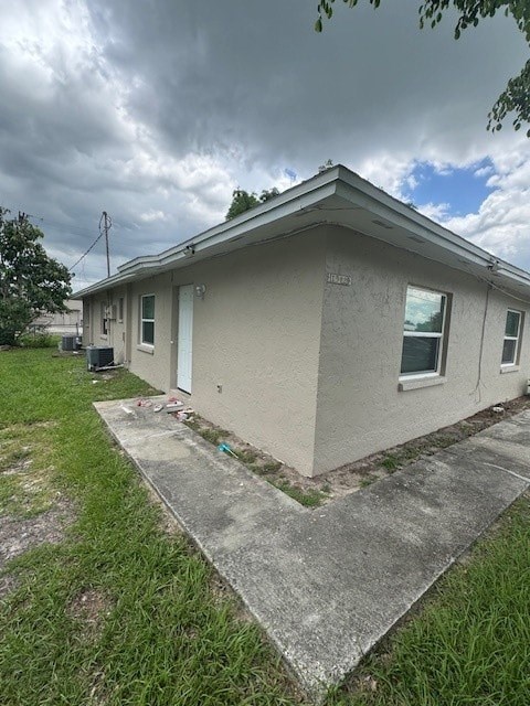 A house with a grey roof and a white wall with a small window.