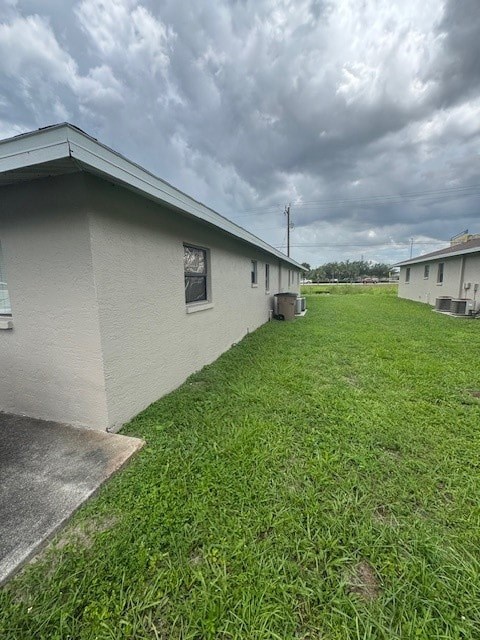 A grassy area in front of a building with a cloudy sky above.