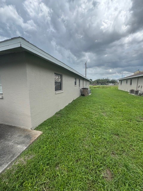A grassy area in front of a building with a cloudy sky above.