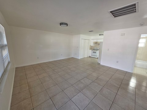 A spacious room with tiled flooring and a ceiling fan.