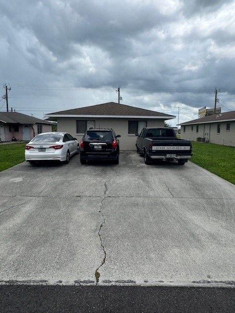 Three cars parked in a driveway in front of a house.