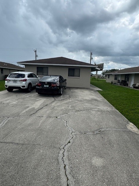 A white car is parked in a driveway next to a black truck.