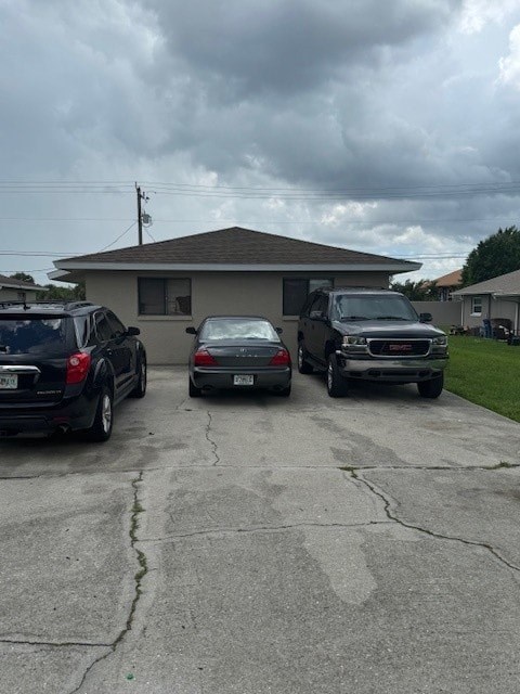Three cars are parked in a driveway in front of a house.