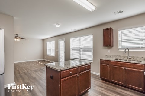 A kitchen with wooden cabinets and a marble countertop.