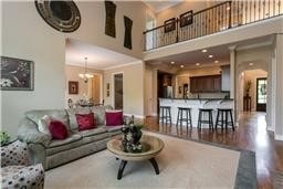 A spacious living room with a grey sofa and a coffee table.