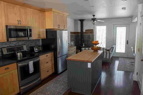 A kitchen with wooden cabinets and a black refrigerator.