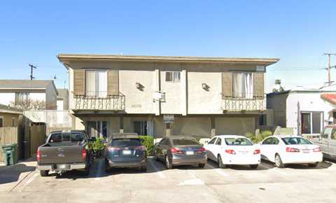 A building with the number 4078 on it has cars parked in front.