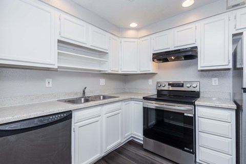 A kitchen with white cabinets and a black oven.