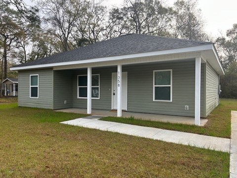 A small house with a grey roof and white trim.