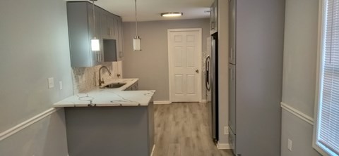 A kitchen with a white counter top and a sink.
