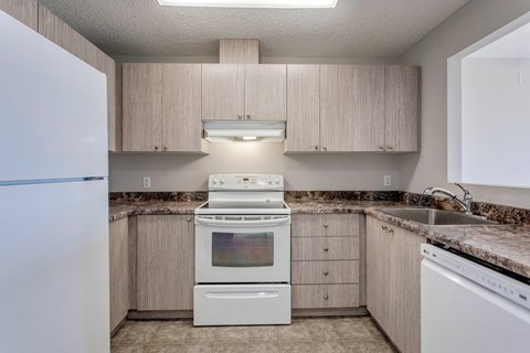 A kitchen with a white oven and sink.
