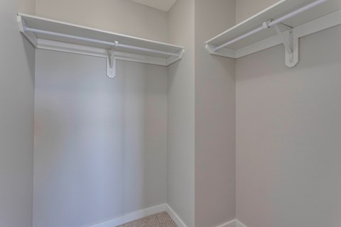 A white closet with two white shelves.