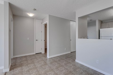 A spacious room with a door and a wall-mounted mirror.
