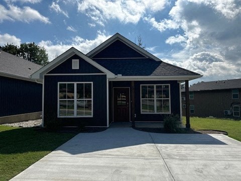 A blue house with a white door and windows.