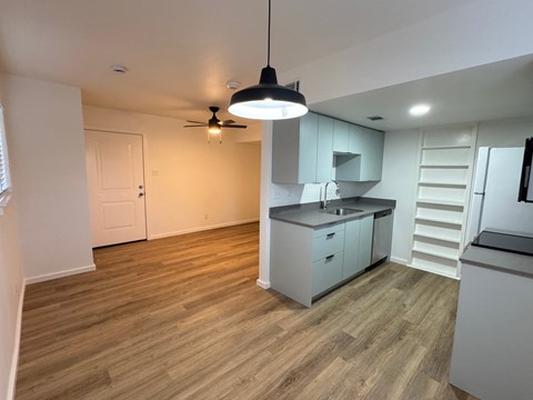 A kitchen with a fan hanging from the ceiling.