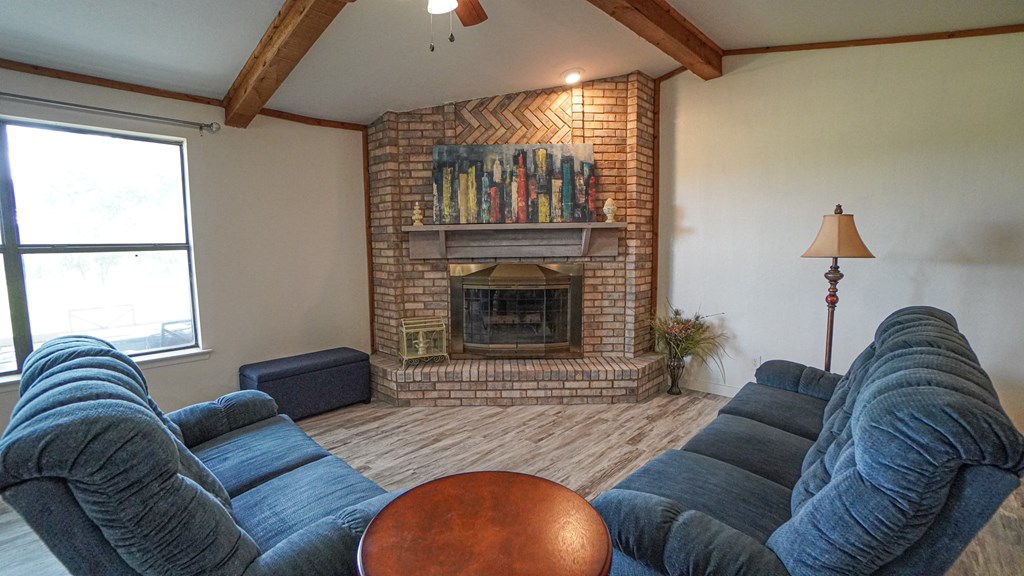 A living room with a fireplace and a blue couch.