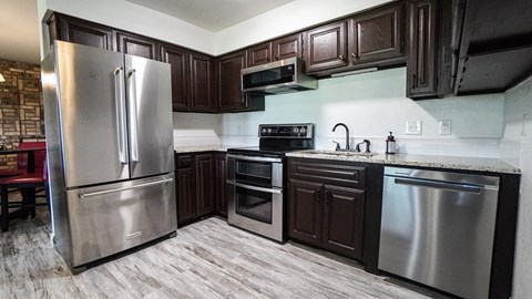 A kitchen with a stainless steel refrigerator and oven.