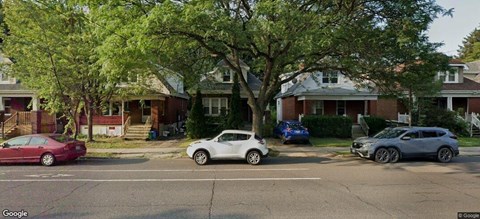 A street view with cars and houses.