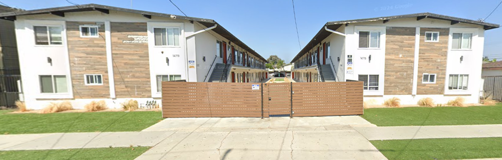 A gated community with two buildings in the background.