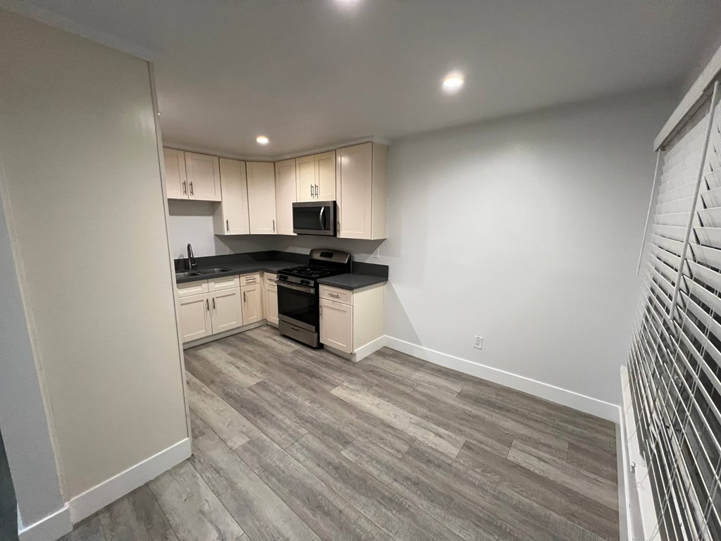 A kitchen with a black countertop and white cabinets.