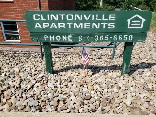 A sign for Clintonville Apartments with a phone number on it.