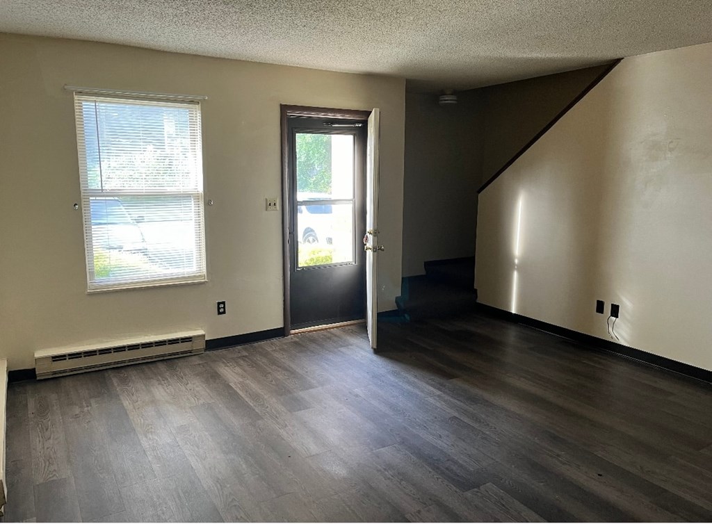 A room with a door, window, and stairs.