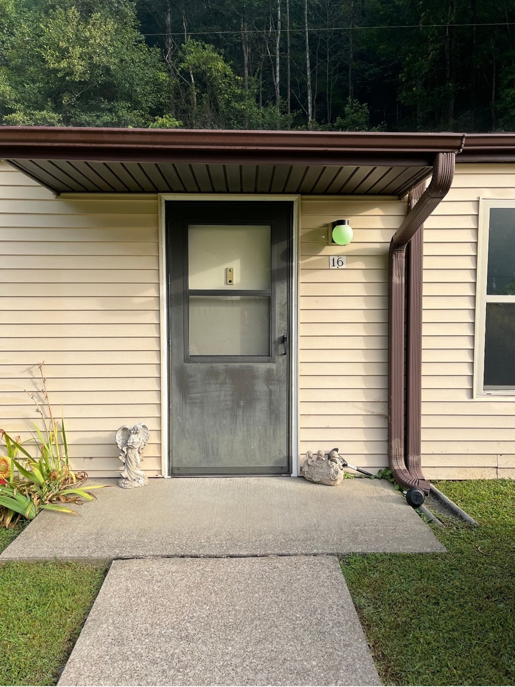 A house number 16 with a grey door and a brown roof.