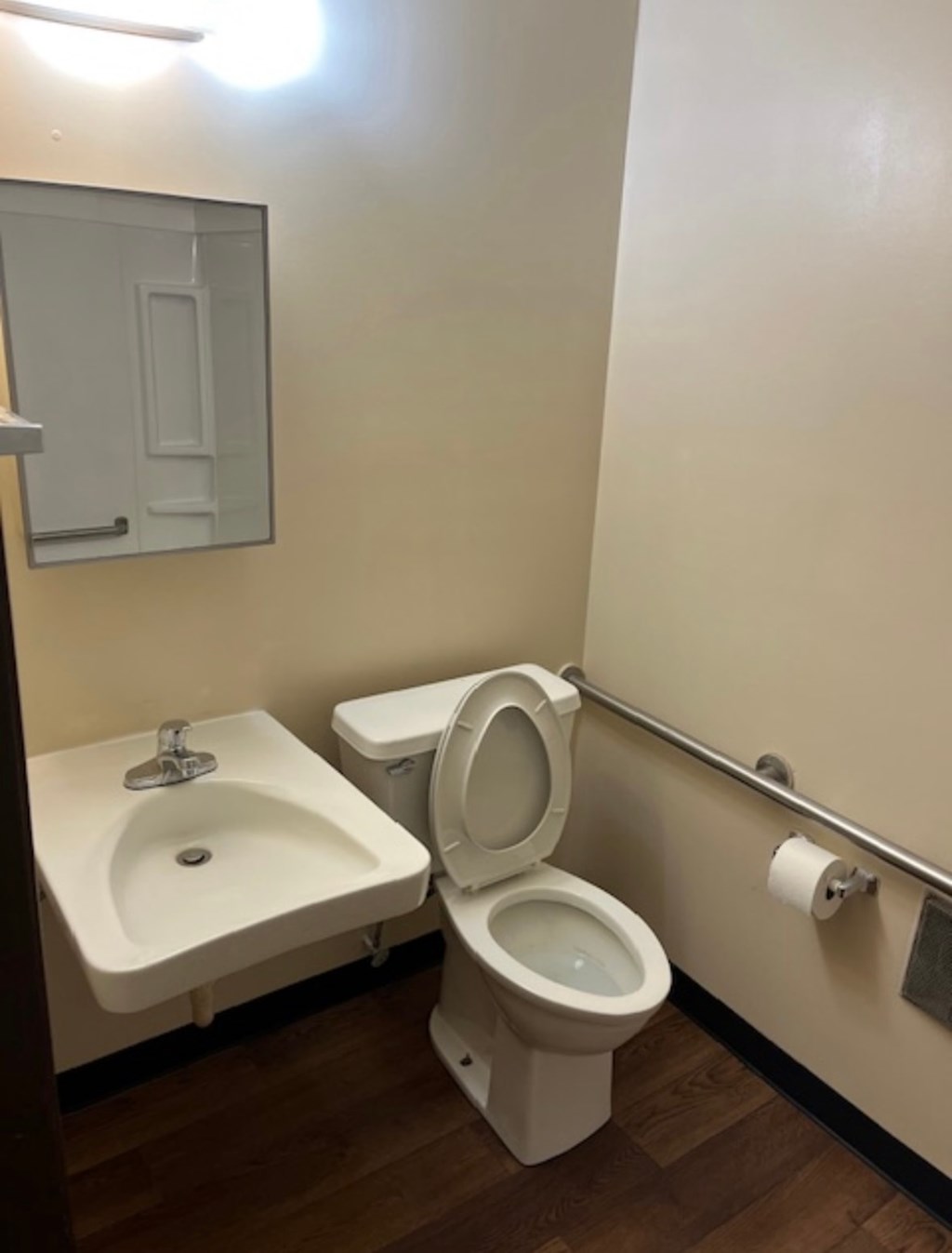 A white toilet sits next to a sink in a small bathroom.
