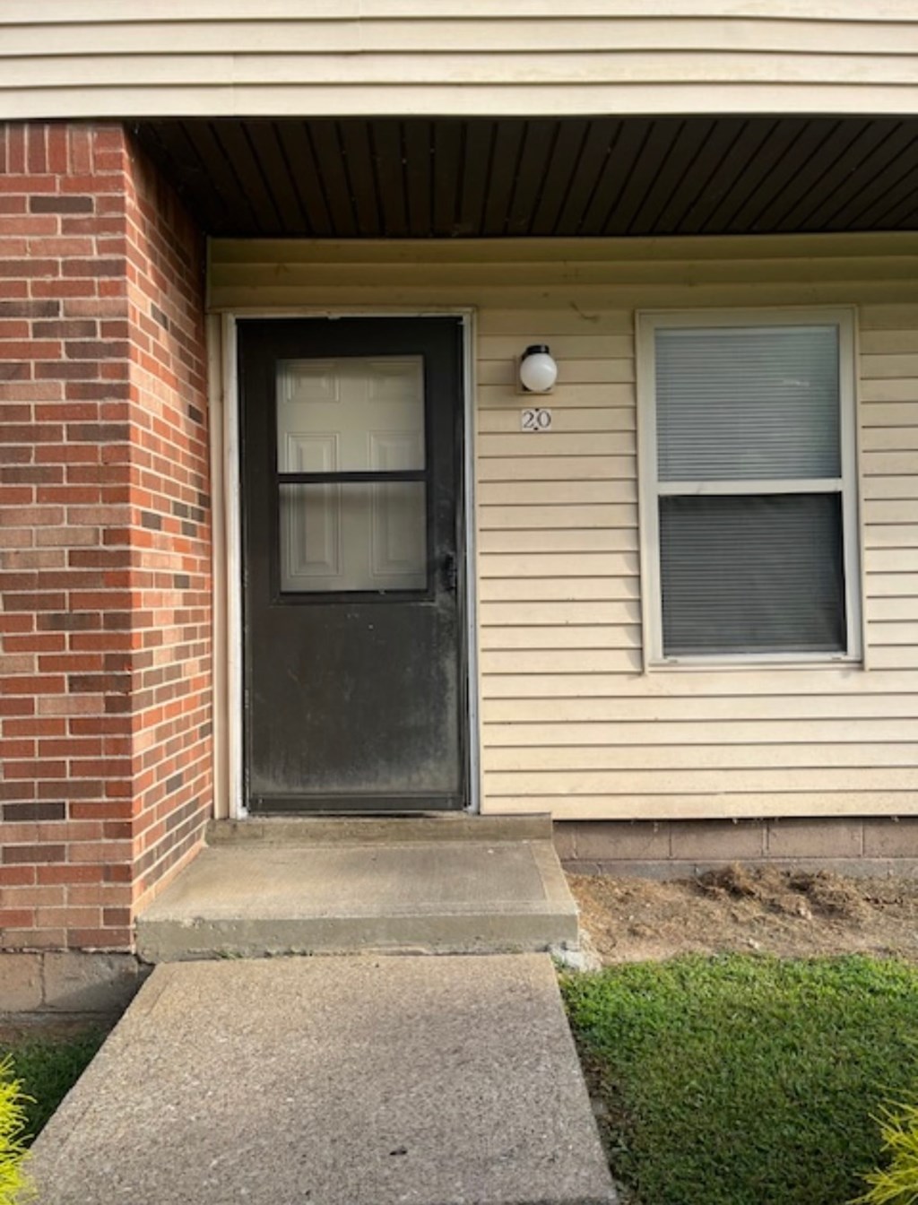 A house numbered 20 has a black door and a window.