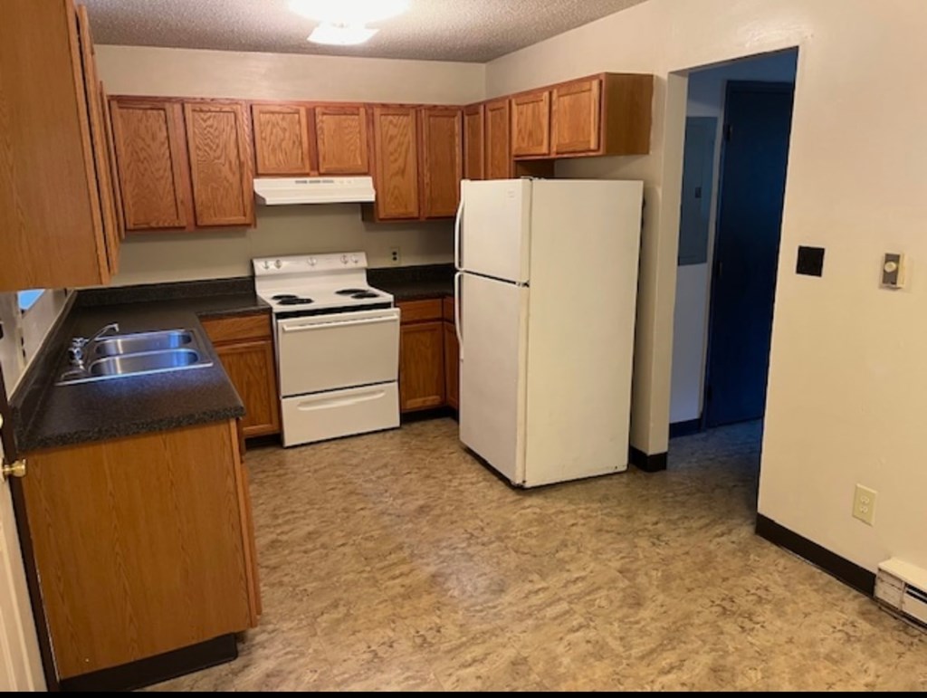 A kitchen with a white fridge and a white stove.
