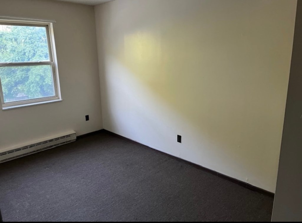 A room with a window and a wall socket.