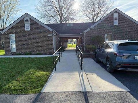 A brick building with a car parked in front.