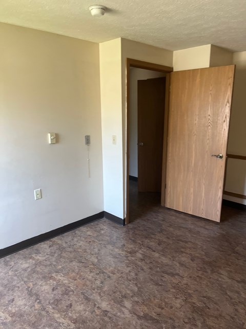 A room with a tan wall and a brown door.