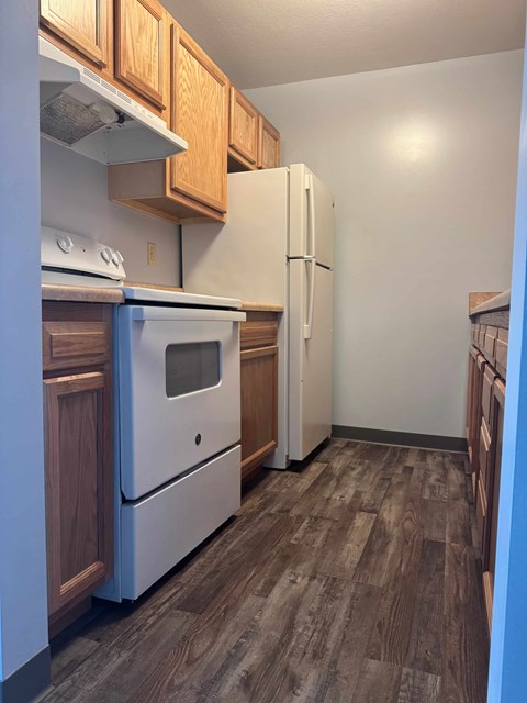 A kitchen with a white oven and refrigerator.