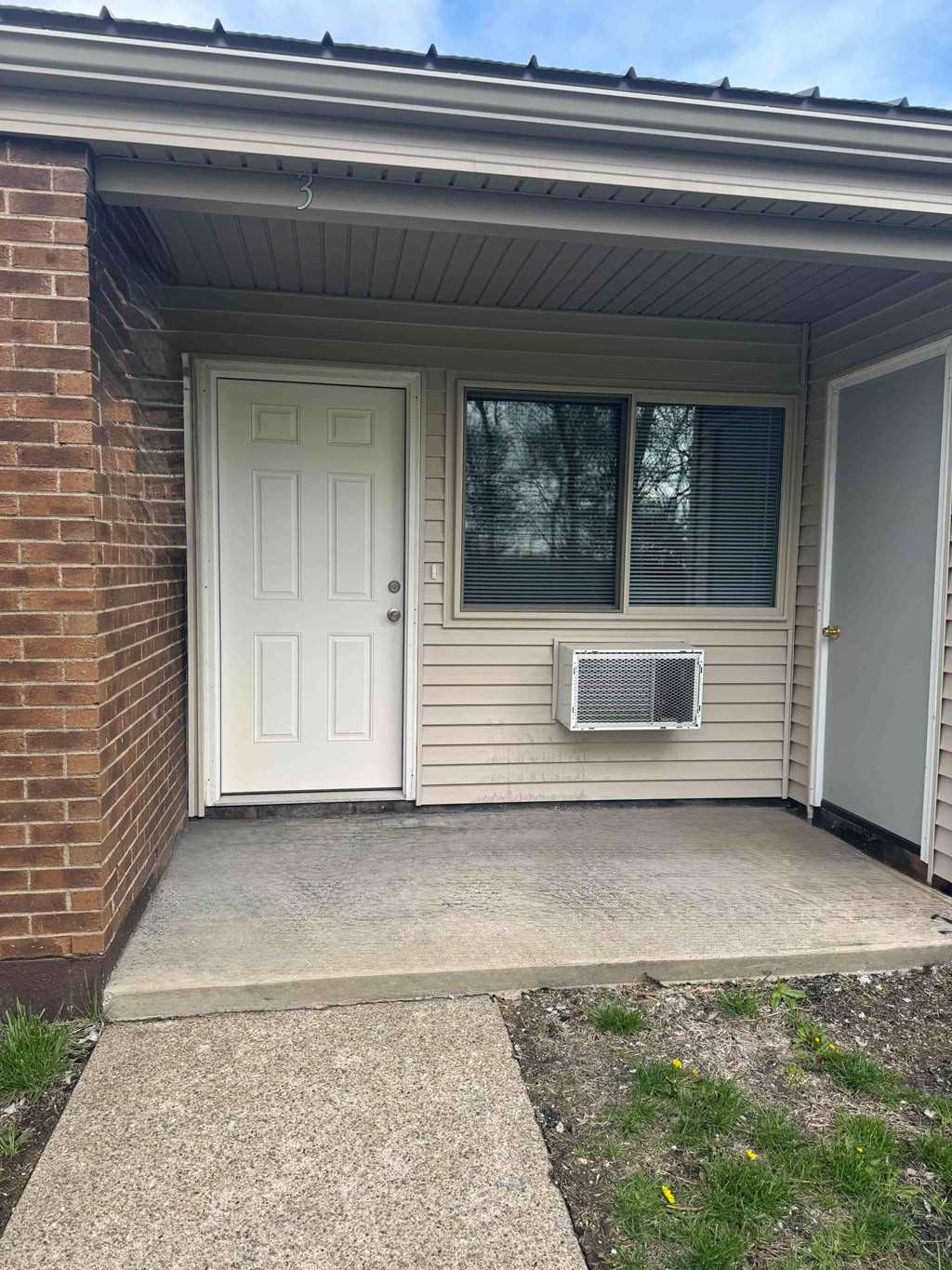 A white door is on the left side of a house.
