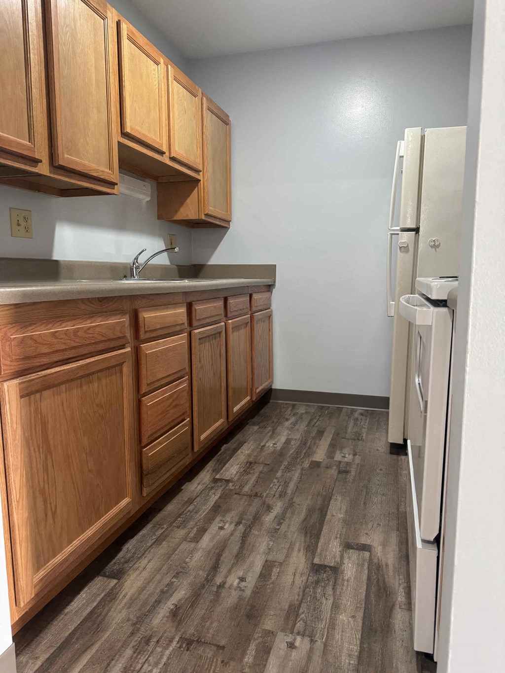A kitchen with wooden cabinets and a white refrigerator.