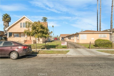 A residential street with houses and a parked car.