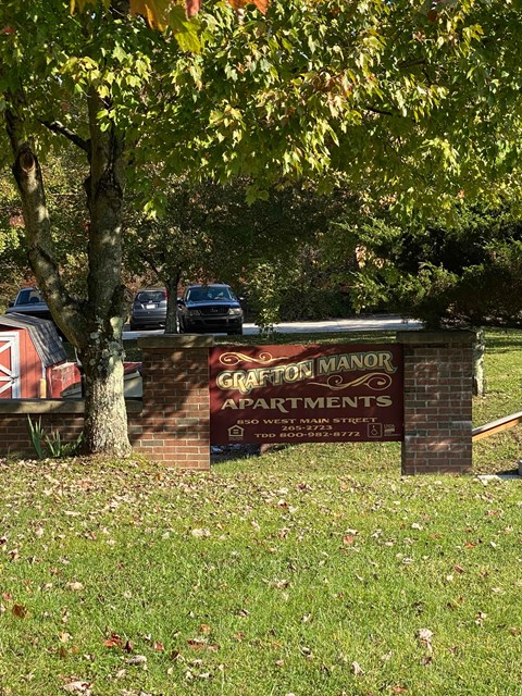 A sign for Granton Manor Apartments is displayed in front of a tree.
