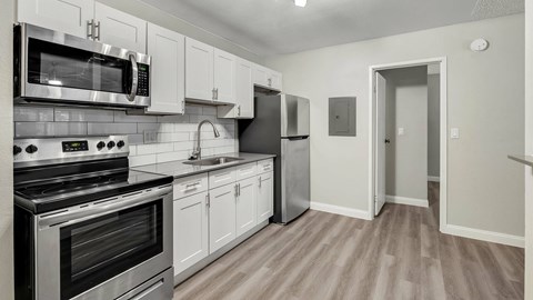 A kitchen with white cabinets and stainless steel appliances.