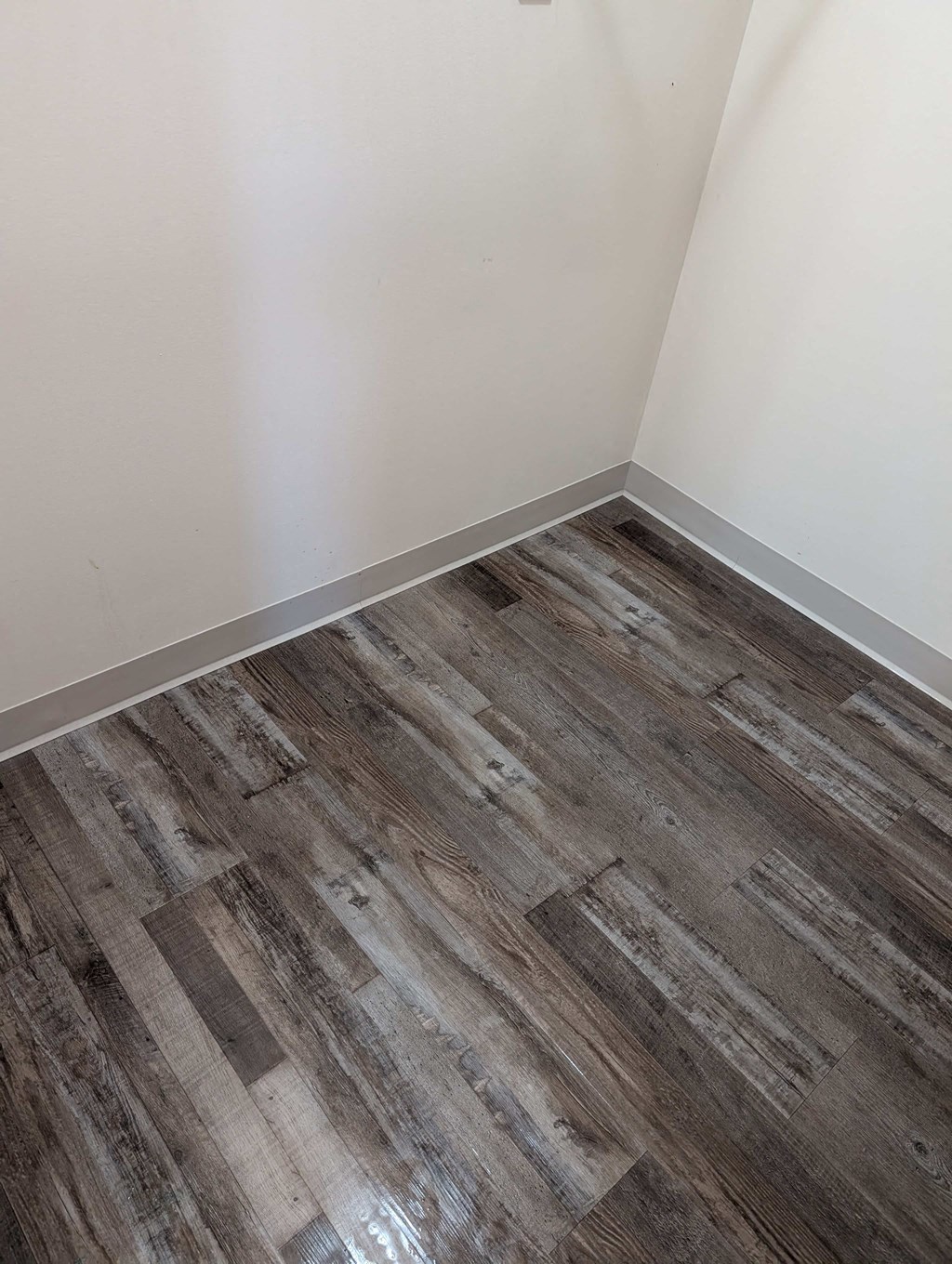A room with a wooden floor and white walls.