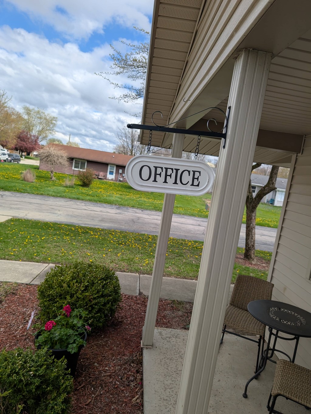 A sign that says "OFFICE" hangs on a porch.