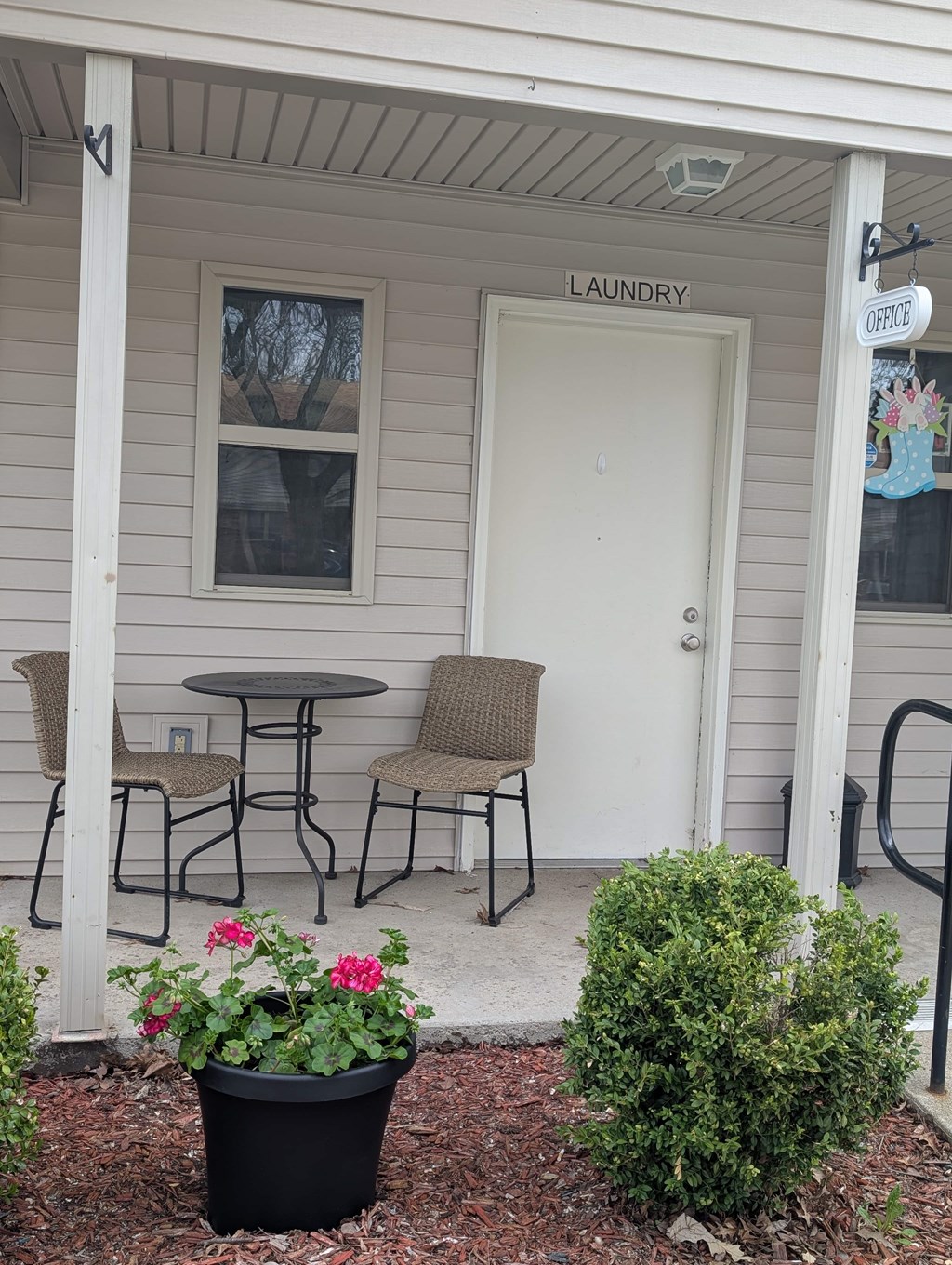A small white building with a laundry sign on the door.