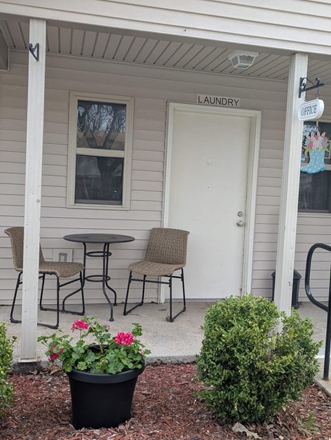 A small white building with a laundry sign on the door.
