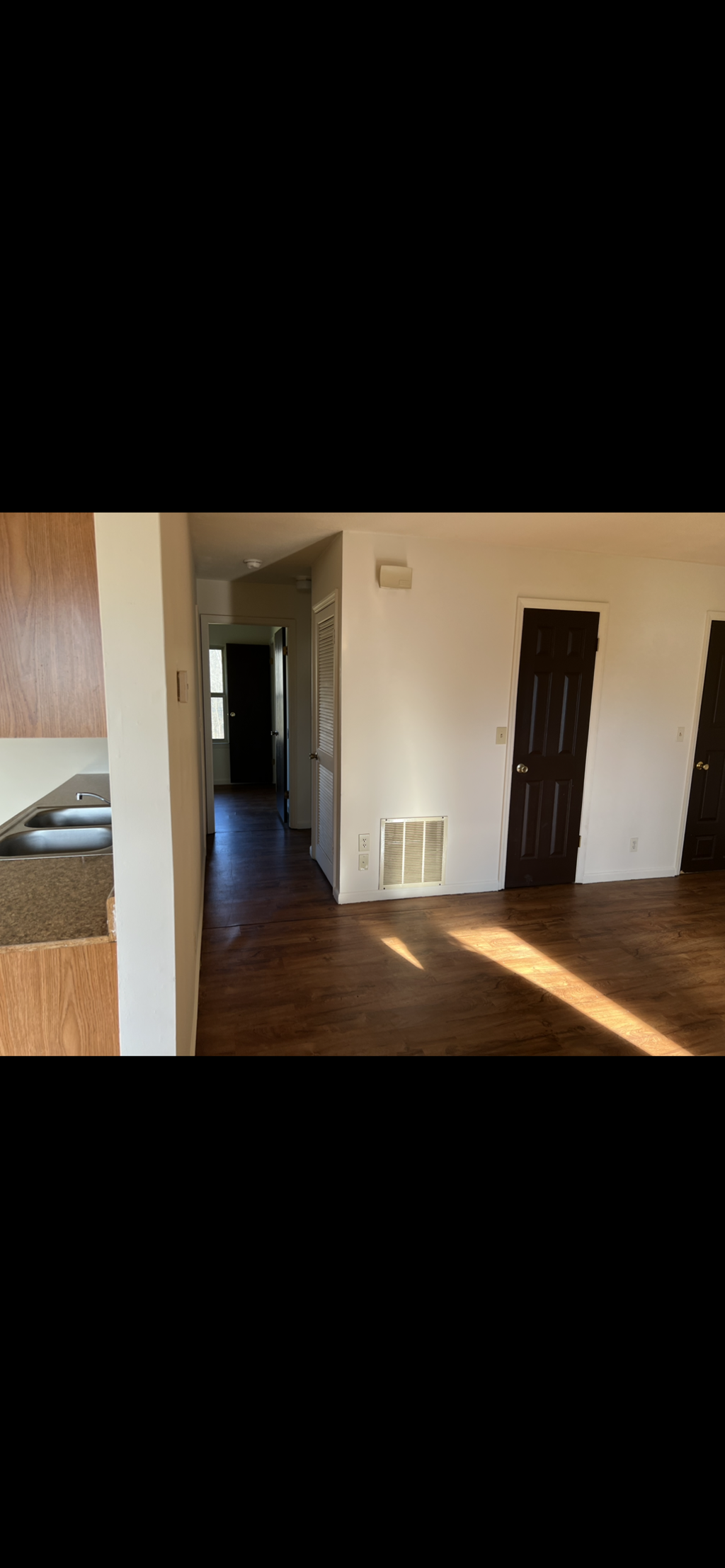 A hallway with a door on the right and a light on the wall.